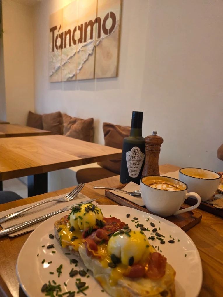 Tostada benedict y un café con leche, con el logo de Tánamo en la pared